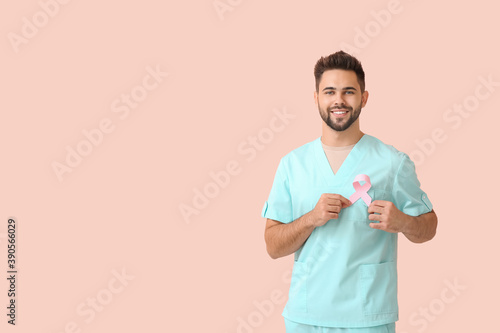 Doctor with pink ribbon on color background. Breast cancer awareness concept