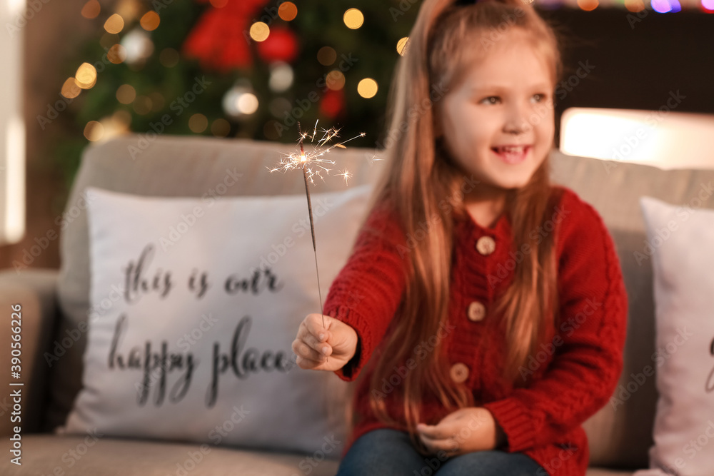 Cute little girl with sparkler celebrating Christmas at home Cute little girl with sparkler celebrating Christmas at home
