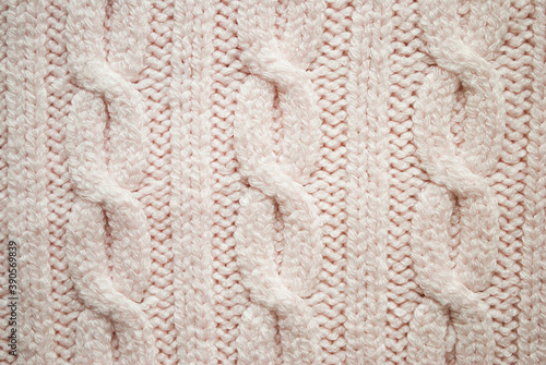 Texture of pink knitted sweaters ornament. Chain Cable stitch knit fabric background closeup, soft focus