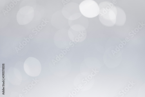 White bokeh lights abstract background. Defocused bokeh on soft gray background.
