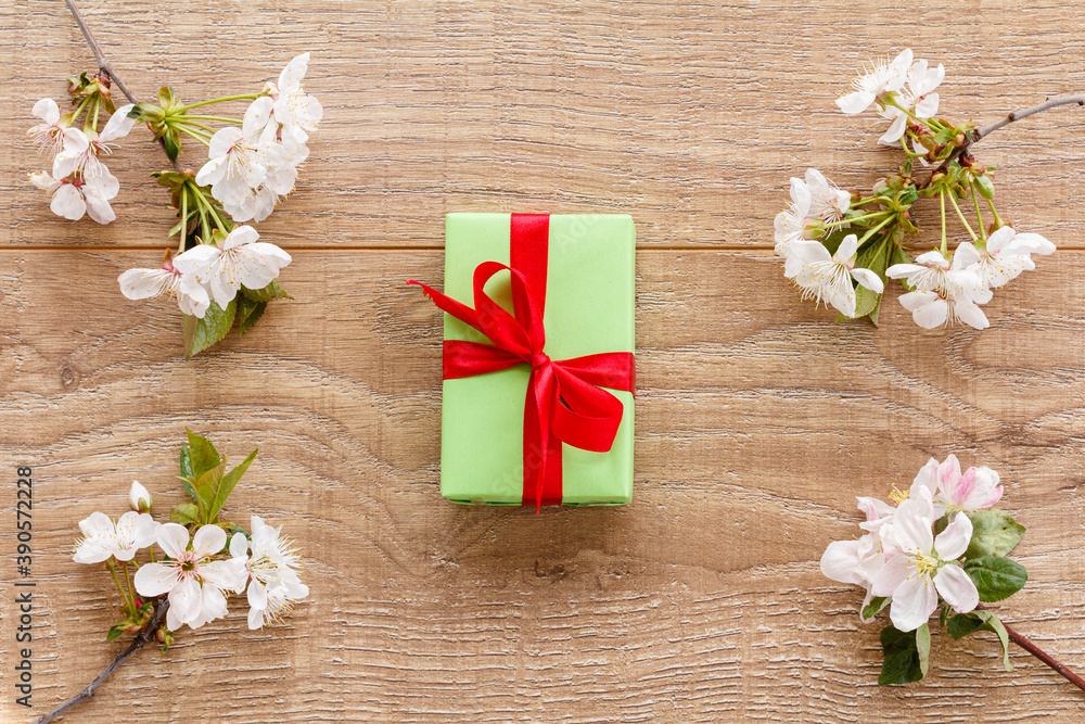 Gift box with cherry flowers on the wooden background. Gift box with cherry flowers on the wooden background.