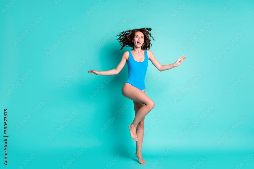 Full length photo of cheerful lady enjoy exotic ocean resort feel excited wear blue swimwear isolated over teal color background Full length photo of cheerful lady enjoy exotic ocean resort feel excited wear blue swimwear isolated over teal color background