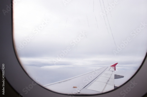 Looking out scratch window on airplane.