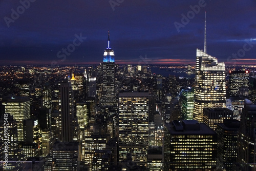 New york city lights of business offices in Manhattan at dusk or dawn. Urban cityscape at twilight. Concept of overpopulated megapolis. USA America. Home office concept during coronavirus.  
