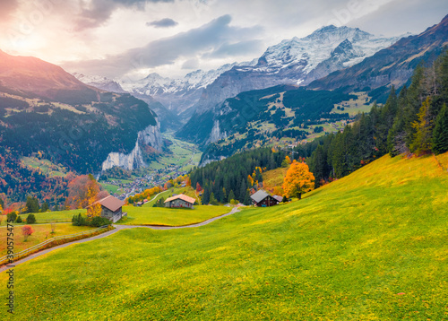 View from flying drone of Wengen village, district of Lauterbrunnen. Great sunrise scene of Swiss Alps. Astonishing autumn landscape of Switzerland countryside, Europe.