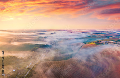 Foggy autumn sunrise on countryside. Exciting morning view from flying drone of village and plowed field  Ternopil region  Ukraine  Europe. Traveling concept background.