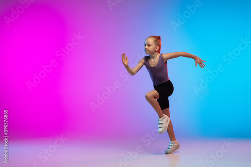 Fototapeta Naklejka Na Ścianę i Meble -  Healthy. Teenage girl, professional runner, jogger in action, motion isolated on gradient pink-blue background in neon light. Concept of sport, movement, energy and dynamic, healthy lifestyle.