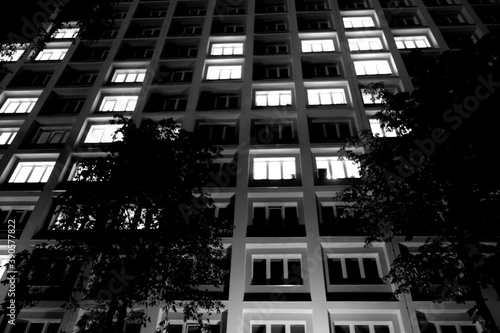 Windows of residential building at night. Black and white