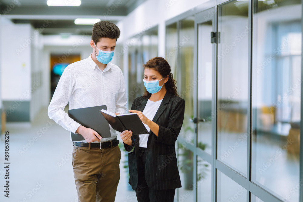 Two manager in protective face masks having an argument discussing business Issue. Holds a folder with important documents in his hands. Covid-19. Two manager in protective face masks having an argument discussing business Issue. Holds a folder with important documents in his hands. Covid-19.