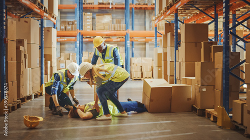 Cuadro en lienzo Warehouse Worker Has Work Related Accident Falls while Trying to Pick Up Cardboard Box from the Shelf