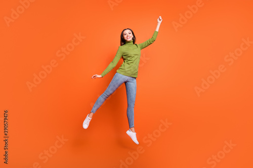 Full size photo of young girl happy positive smile crazy jump active have fun isolated over orange color background © deagreez