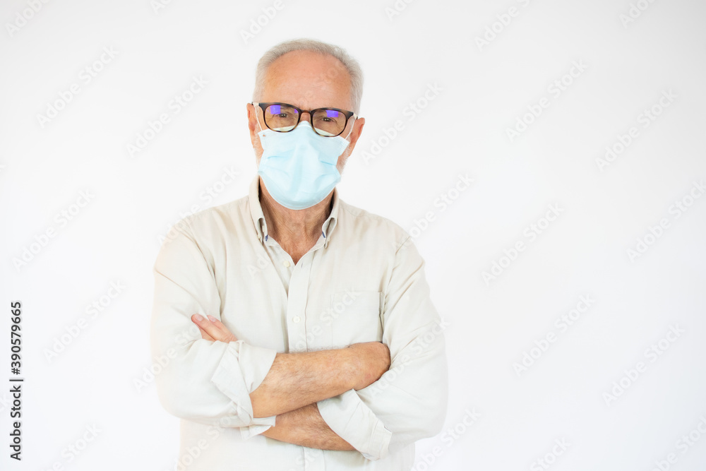 Portrait of cheerful senior man wearing surgical mask looking at camera over white background. Portrait of cheerful senior man wearing surgical mask looking at camera over white background.