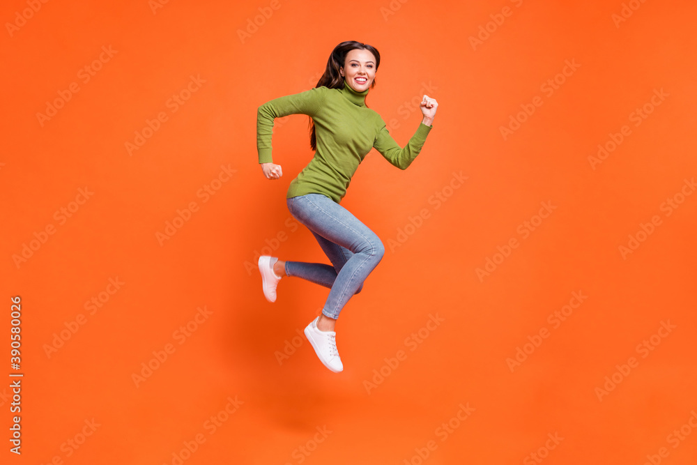 Full size profile sid photo of young active crazy girl have fun enjoy run jump happy smile isolated over orange color background