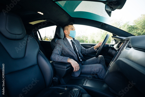 Businessman wearing medical mask in prevention for coronavirus and driving his car to work. Pandemic. Citizens. Lockdown safety. Businessman healthcare © uflypro
