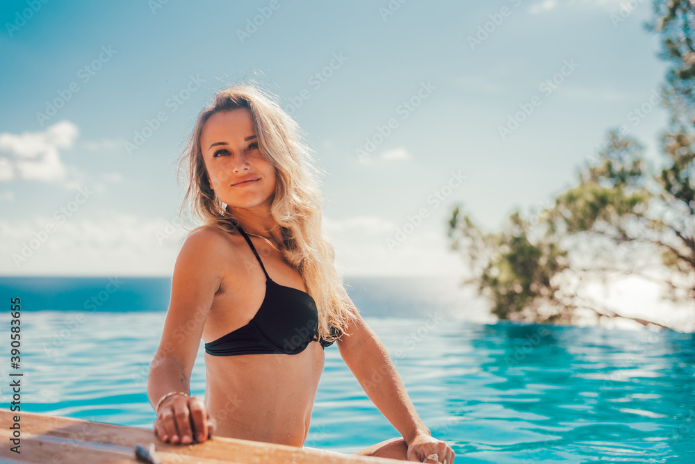 Girl by the pool, portrait on the background of the pool going to the sea Girl by the pool, portrait on the background of the pool going to the sea
