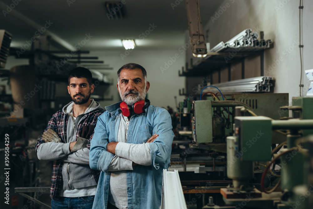 Aluminium and PVC industry workers standing crossed arms looking at camera Aluminium and PVC industry workers standing crossed arms looking at camera