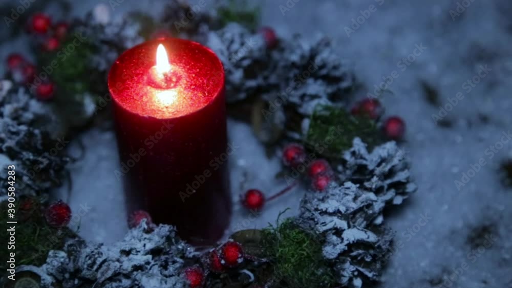 A lighted candle on Christmas night against the background of artificial snow A lighted candle on Christmas night against the background of artificial snow