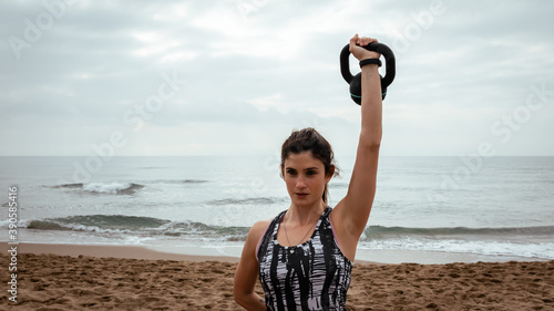 Young beautiful woman working out at the beach in the morning