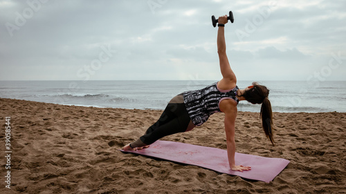 Young beautiful woman working out at the beach in the morning