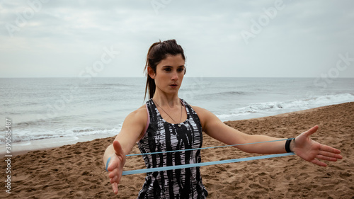 Young beautiful woman working out at the beach in the morning
