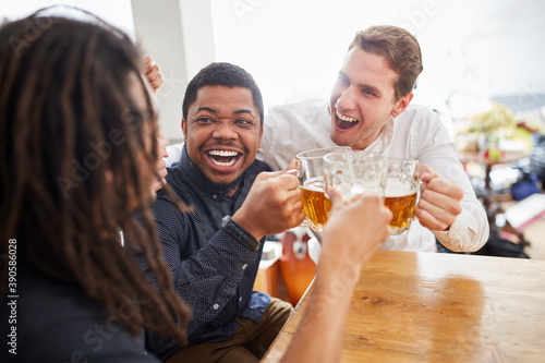 Glückliche Männer als Freunde jubeln beim Bier trinken