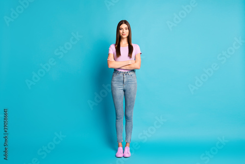 Full lenght photo of sweet charming woman wear casual violet t-shirt denim trousers arms crossed isolated blue color background