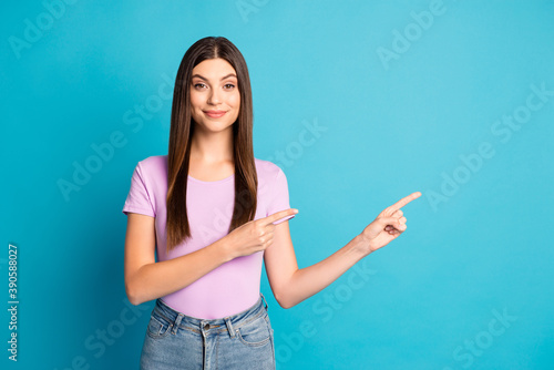Photo of adorable young lady dressed casual outfit pointing two arms fingers empty space isolated blue color background