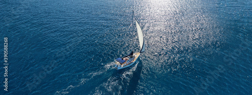 Aerial drone ultra wide photo of beautiful sailboat sailing in tropical exotic bay with emerald clear sea