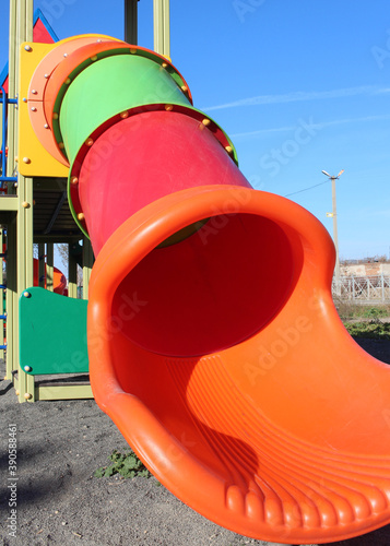 children's bright plastic slide with a pipe on the street in the Playground for entertainment