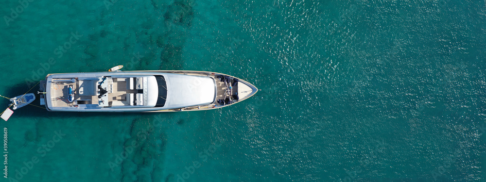 Aerial drone top down ultra wide photo of luxury yacht anchored in tropical exotic island turquoise sea Aerial drone top down ultra wide photo of luxury yacht anchored in tropical exotic island turquoise sea