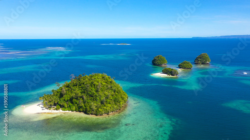 Fototapeta Naklejka Na Ścianę i Meble -  Small Island with beautiful beach, palm trees by turquoise water view from above. Britania Islands, Surigao del Sur, Philippines.