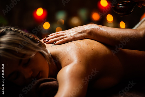 Beautiful girl receiving oil massage in beauty salon