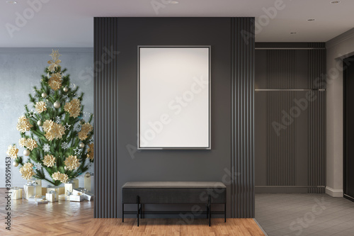 Modern entrance hallway with a vertical mockup poster in a metal frame over a gray pouf. Christmas tree with gifts, wardrobe with an entrance door are in the background. 3d render