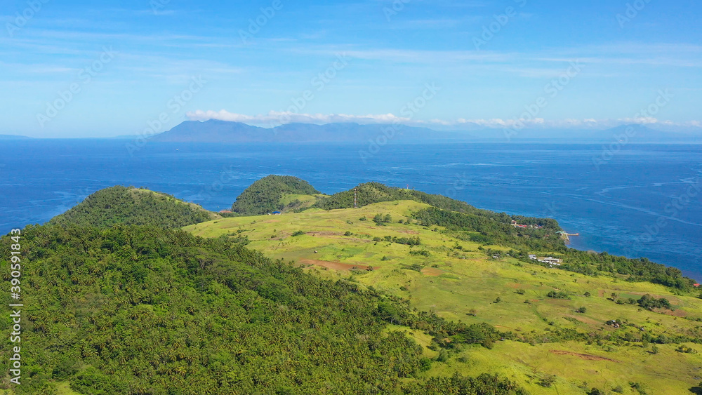 Seascape on tropical island with with blue sea. Slopes of mountains with evergreen vegetation. Philippines, Mindanao. Surigao City. Surigao del Norte. Seascape on tropical island with with blue sea. Slopes of mountains with evergreen vegetation. Philippines, Mindanao. Surigao City. Surigao del Norte.