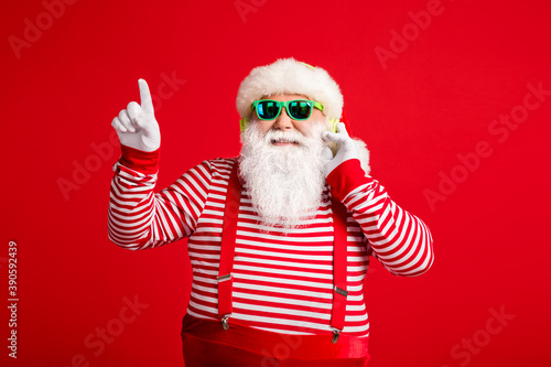 Portrait of his he handsome bearded fat overweight cheerful Santa listening single hit sound having fun rest relax chill amusement free time isolated bright vivid shine vibrant red color background © deagreez