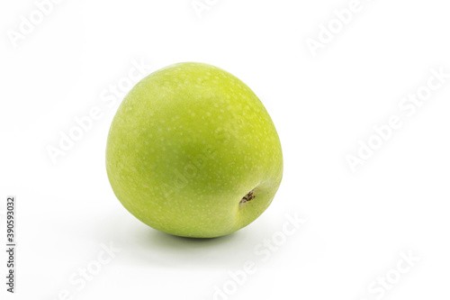 On a white background lies a fresh green apple