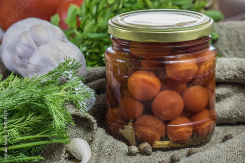 Canned tomatoes in a jar of spices, garlic, pepper and dill