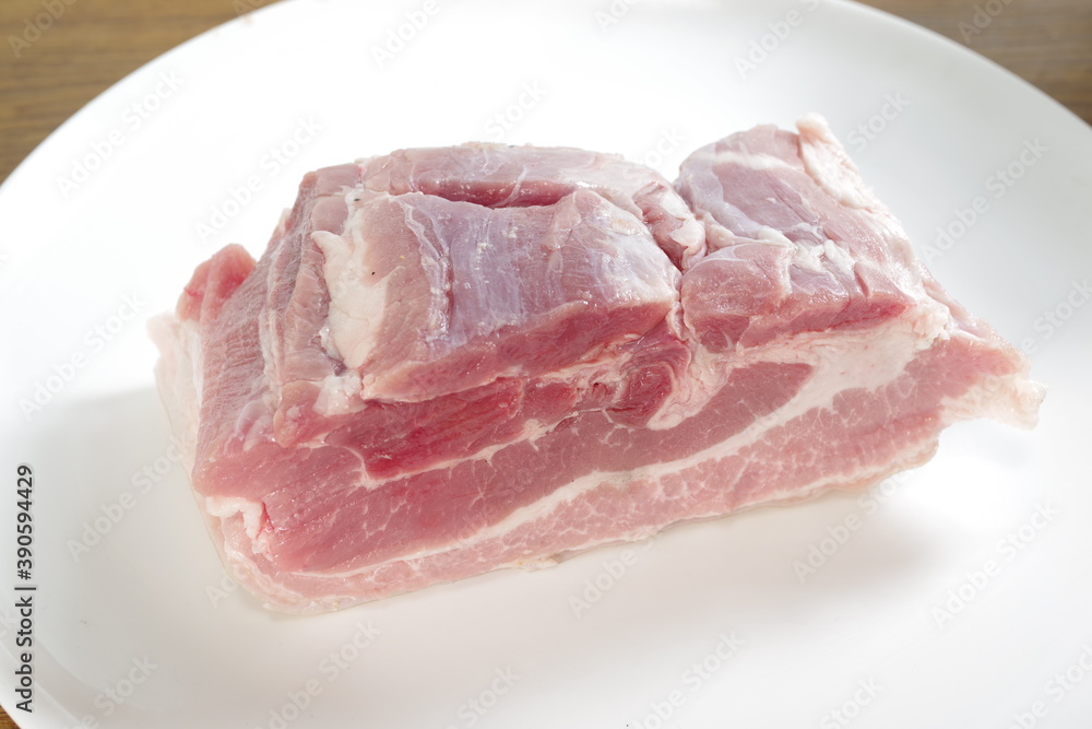 raw bacon with parsley on white plate raw bacon with parsley on white plate