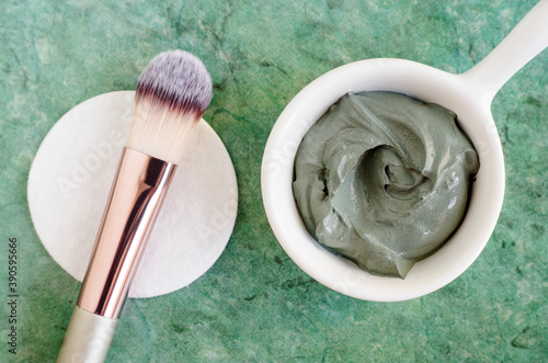 Gray (green) bentonite clay in the bowl. Clay texture close up. Diy mask and body wrap recipe. Natural beauty treatment and spa. Top view, copy space