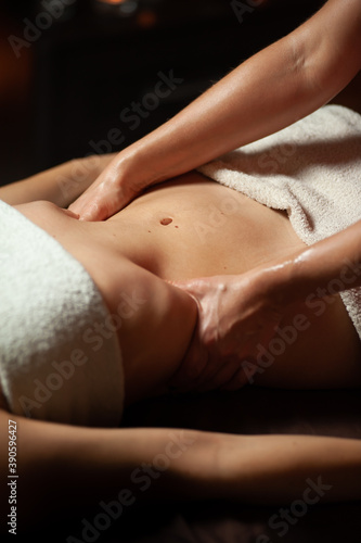 Beautiful young woman having visceral massage in spa center