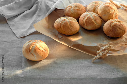 Kaiser or Vienna rolls on table covered with linen tablecloth. photo