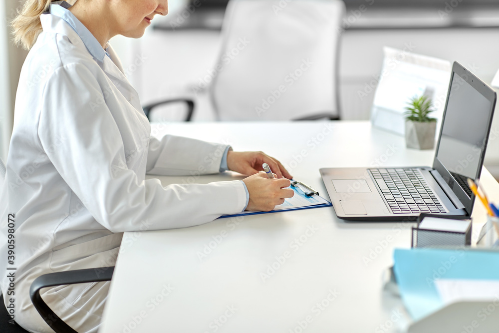 Obraz premium medicine, healthcare and profession concept - female doctor in white coat with laptop computer and medical report at hospital