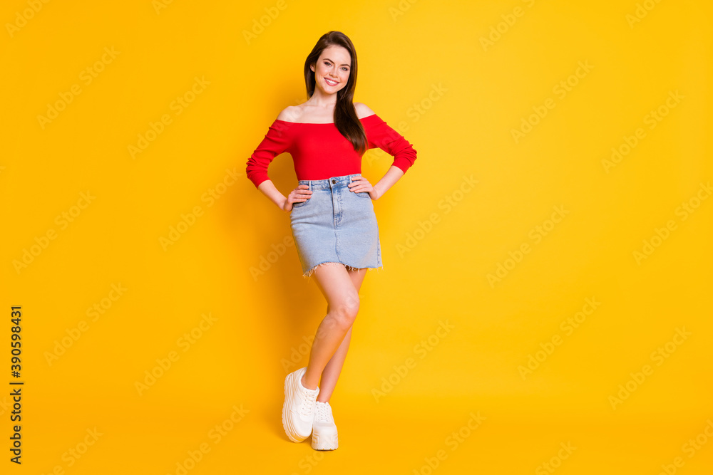 Full length body size view of her she nice attractive lovable gorgeous content cheerful girl posing hands on hips isolated over bright vivid shine vibrant yellow color background Full length body size view of her she nice attractive lovable gorgeous content cheerful girl posing hands on hips isolated over bright vivid shine vibrant yellow color background