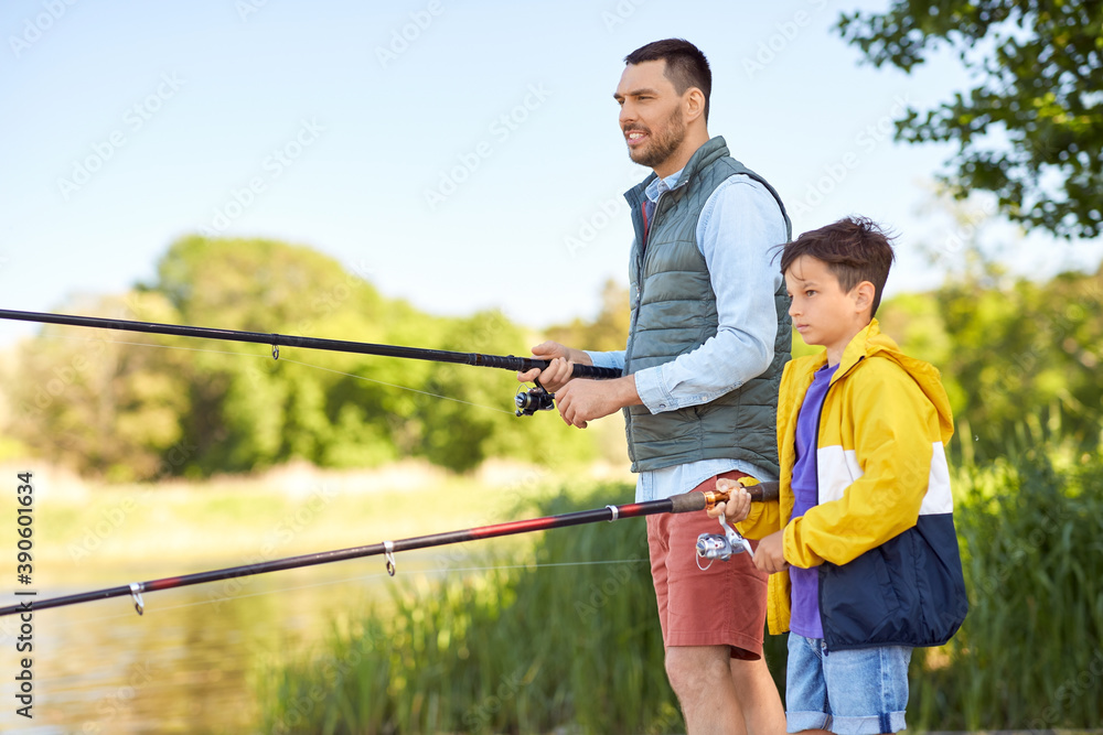 family, generation, summer holidays and people concept - happy smiling father and son with fishing rods on river berth family, generation, summer holidays and people concept - happy smiling father and son with fishing rods on river berth