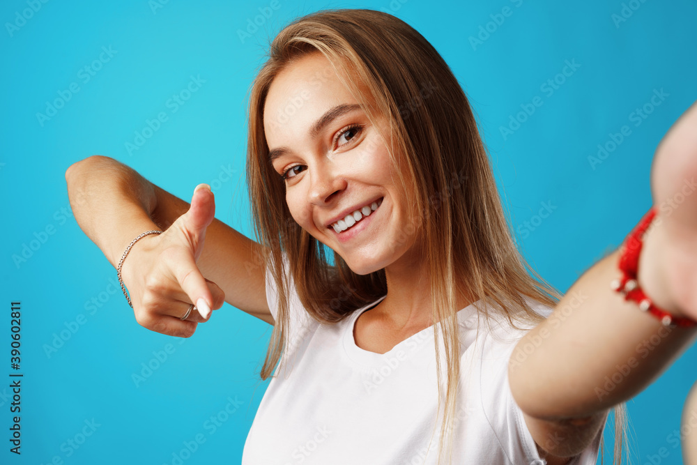 Positive young blonde woman looking at camera and pointing on you Positive young blonde woman looking at camera and pointing on you