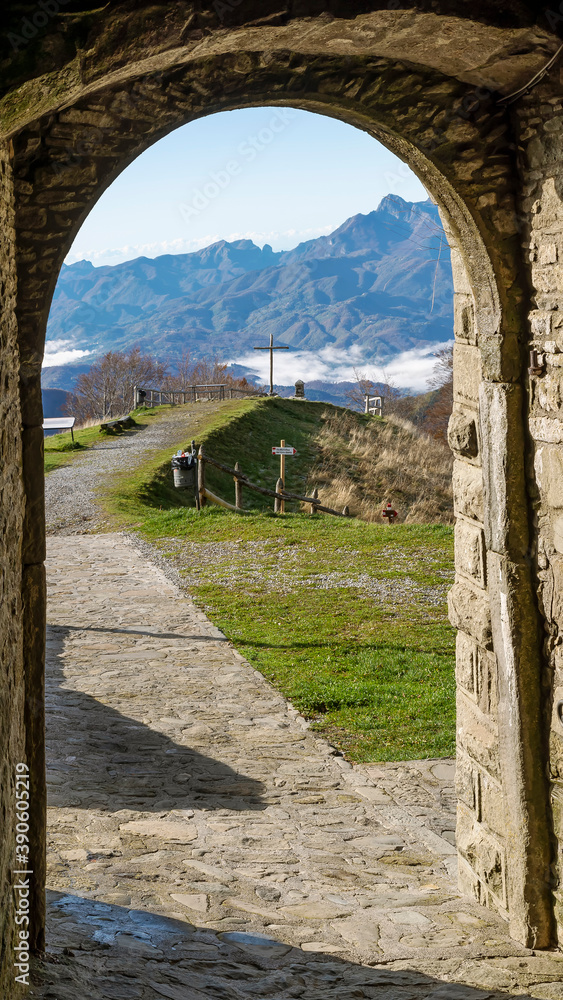 Vertical view of the Garfagnana framed by an arch of the Sanctuary of San Bianco e Pellegrino in San Pellegrino in Alpe, Italy