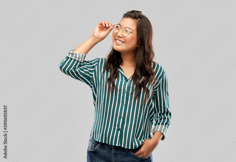 Fototapeta premium people, education and school concept - happy asian woman in glasses or student over grey background