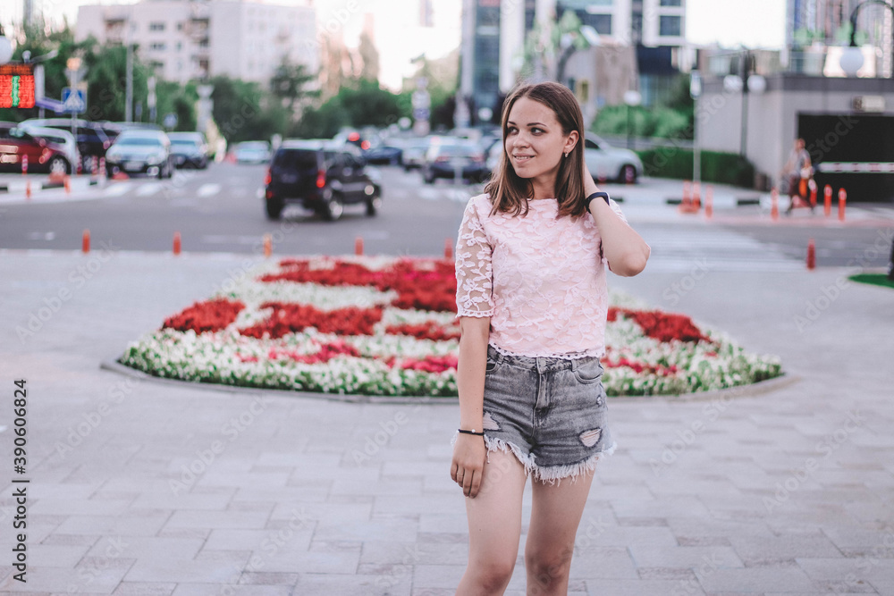 girl in the city near the red flower bed girl in the city near the red flower bed
