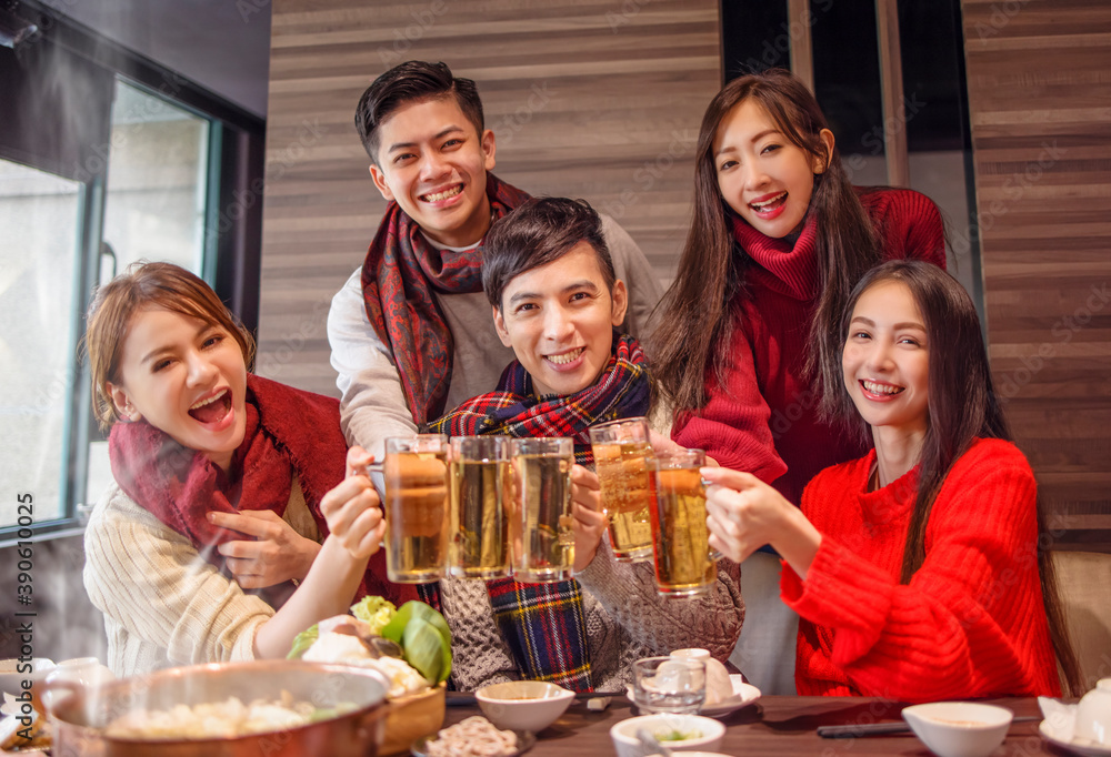 .happy friends drinking and toasting beer at hot pot restaurant .happy friends drinking and toasting beer at hot pot restaurant