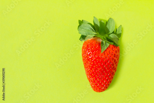 Red fresh strawberries on green background.